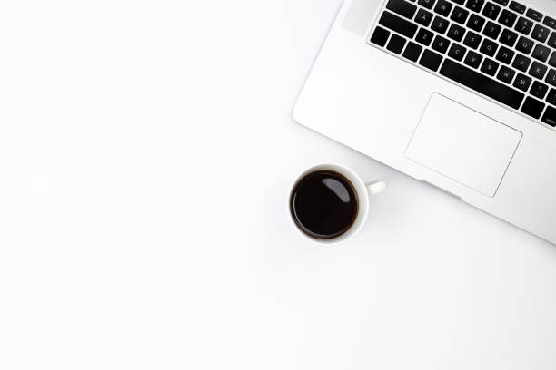 istock Laptop and a cup of black coffee on a white background, top view. 1490710949