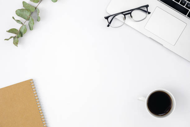 istock Flat lay white background with laptop, notepad, coffee cup and glasses. 1490710963