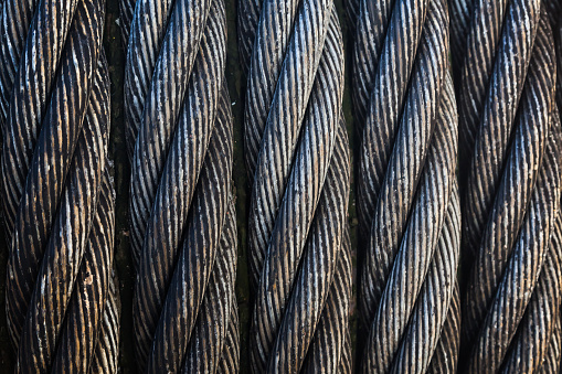 Steel twisted cable wound on a drum, next to each other, close-up.