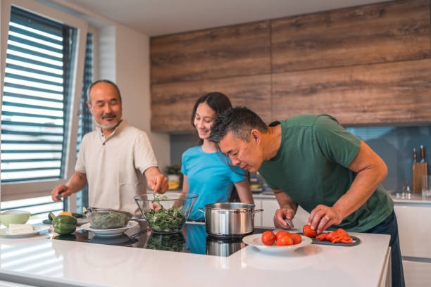 istock Cheerful Mix-Age Asian People Preparing A Meal In A Domestic Kitchen 1490711317