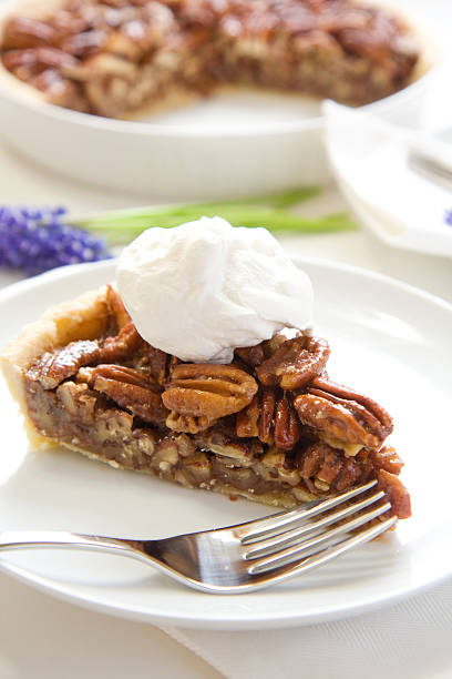 A delicious slice of pecan pie Pecan Pie slice wih a generous dollop of whipped cream grape hyacinth photos stock pictures, royalty-free photos & images