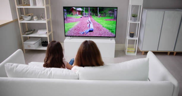 istock Smiling Mother And Daughter Watching Television 1490711779