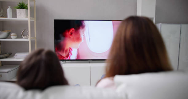 istock Smiling Mother And Daughter Watching Television 1490711846
