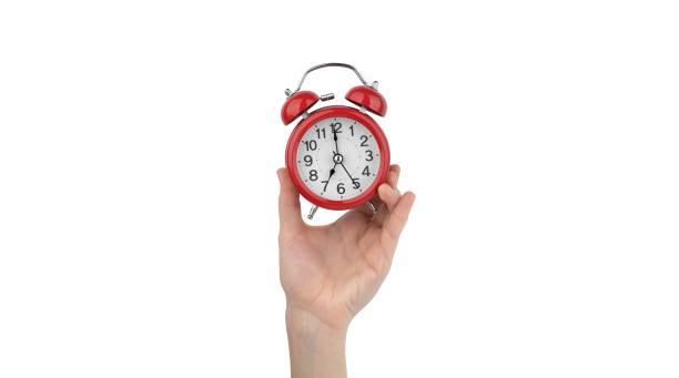 istock Isolated woman's hand holds a red alarm clock 1490712030