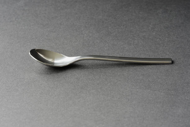 istock Shiny little spoon with black background and beautiful shadows. 1490713554