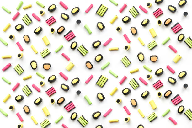 Seamless pattern of colorful lollipop and licorice candy on white background. View from above. Flat lay.