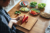 Unrecognizable Woman Cutting a Paprika on a Kitchen Board