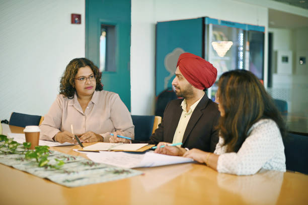 istock Sikh Indian manager discussing engineering drawings with his female colleagues in a co-working office. 1490714841