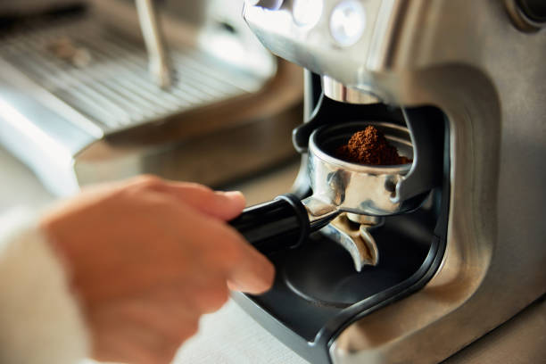 istock Close-up of a woman's hands holding an espresso filter holder for a coffee machine. 1490715698