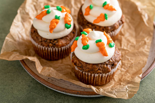 istock Carrot cupcakes with cream cheese frosting decorated with tiny carrots 1490717833