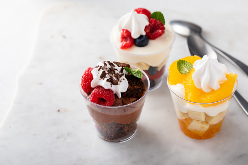 Variety of small desserts in cups, chocolate, berry and orange trifles or parfaits
