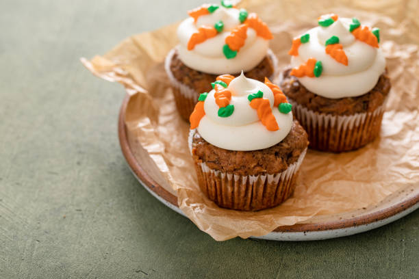 Carrot cupcakes with cream cheese frosting decorated with tiny frosting carrots