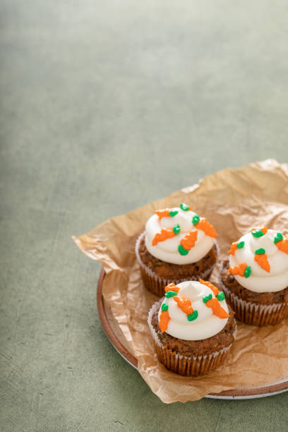 Carrot cupcakes with cream cheese frosting decorated with tiny frosting carrots, Easter dessert idea