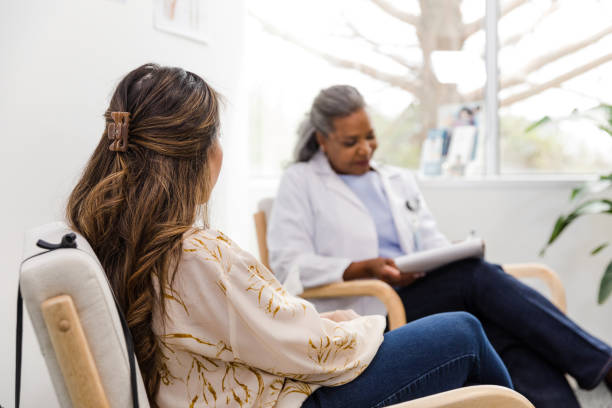 istock Unrecognizable female patient waits quietly while female doctor updates chart 1490719764