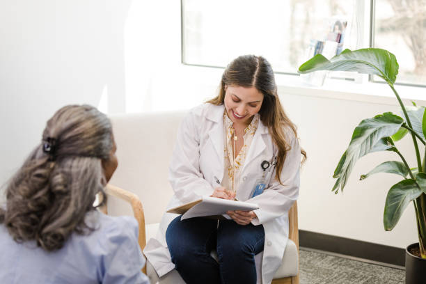 istock Female doctor smiles while updating patient chart 1490719782