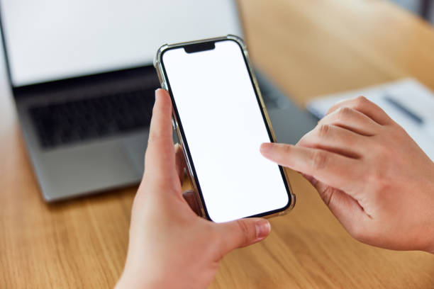 istock A woman holding her mobile phone and touching an empty white display. 1490720882
