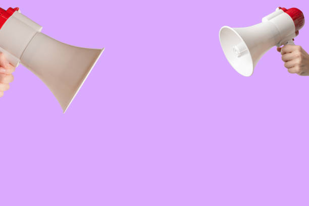 istock Megaphone in woman hands on a purple background. 1490723116