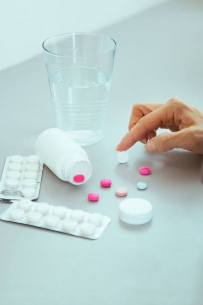 istock Closeup on young woman choosing pills 1490725322