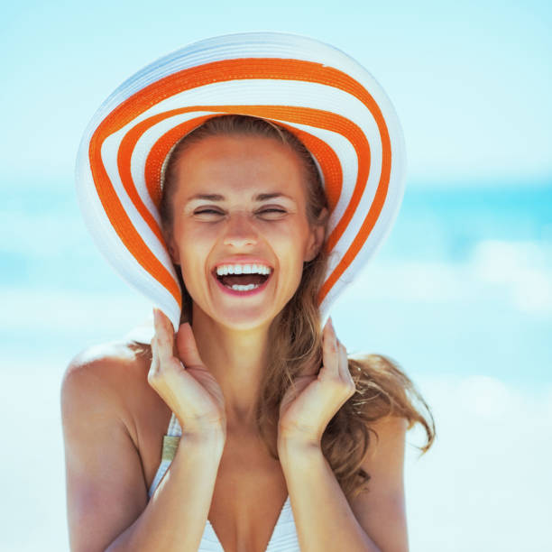 istock smiling young woman in hat on beach 1490726284