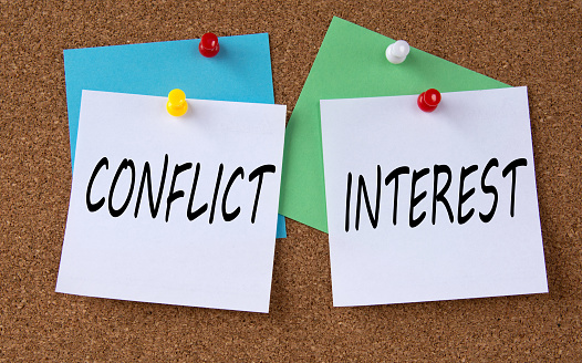 CONFLICT and INTEREST - words on colorful pieces of paper attached to the note board. Info concept