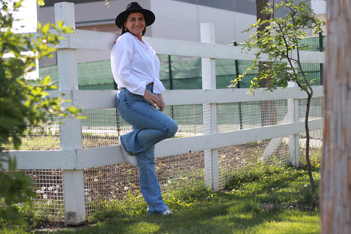 Young fashionable woman with hat in jeans and white shirt