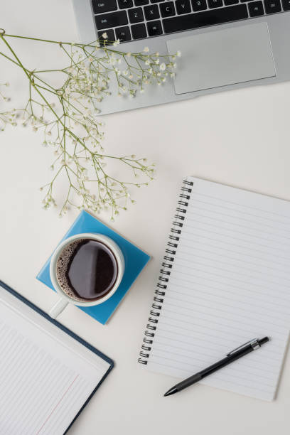 istock Workspace with laptop, office supplies, and coffee cup on white background. Top view. 1490729938