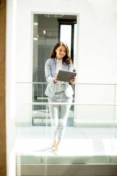 istock Young woman working on digital tablet in the office hallway 1490734982