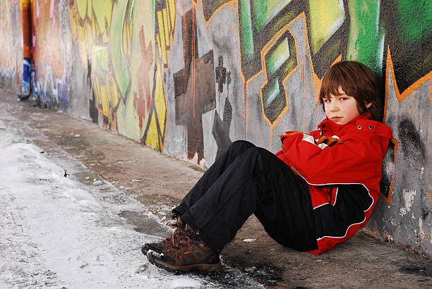 adolescent triste garçon contre un mur de graffiti - adolescene photos et images de collection