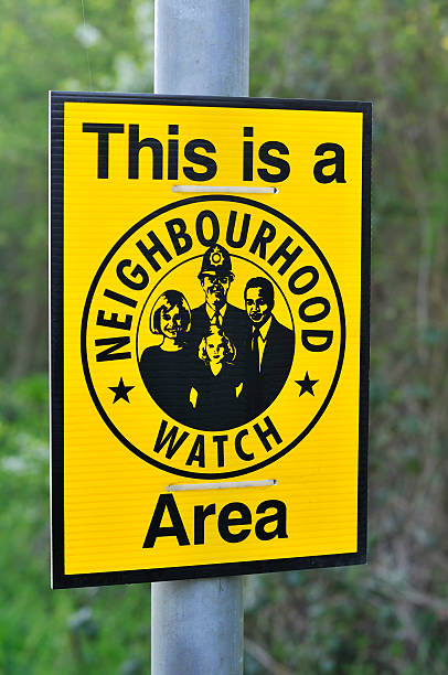 A yellow neighbourhood watch sign on a lamp post UK Neighbourhood watch sign out in a country village. neighborhood crime watch stock pictures, royalty-free photos & images