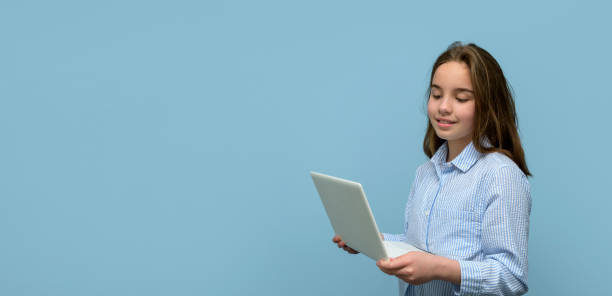 istock Girl with a small white laptop on a blue background. Banner 1490736913