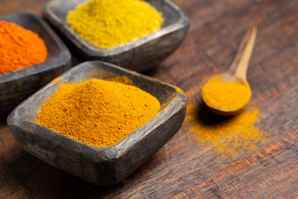 istock Turmeric, pepper and curry powder in container on wooden background 1490737624