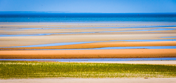 Bands of color create an abstract view of the mile wide Brewster tidal sand flats on Cape Cod.