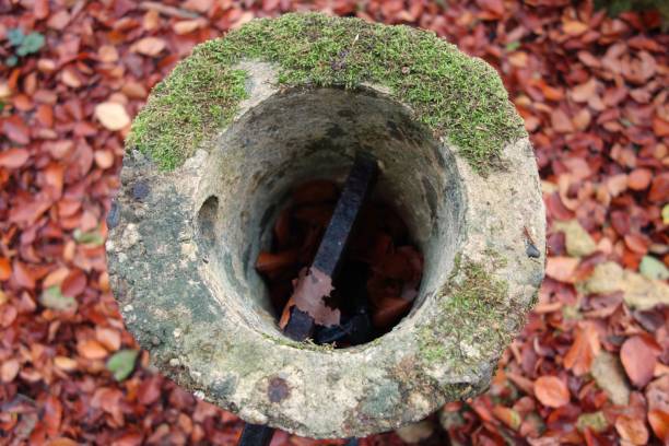 istock Aerial view on a stony, circular, moss covered and hollow pole with an horizontal withered metal stick in it in an autumn scenery 1490743790