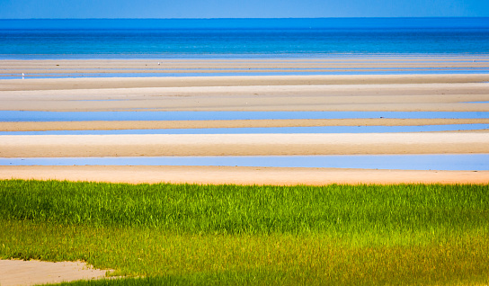 Bands of color create an abstract view of the mile wide Brewster tidal sand flats on Cape Cod.