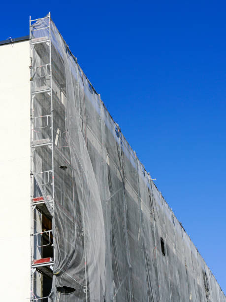 istock Multistorey apartment building facade renovation and thermal insulation, scaffolding with safety net 1490745106