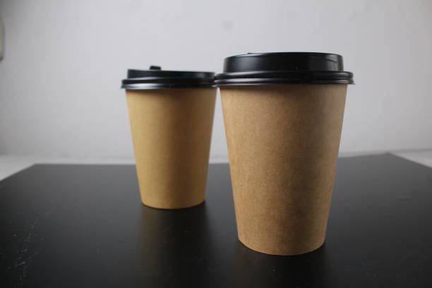 istock Empty paper cup for coffee made from biodegradable brown paper on a white background. Two versions with lid and without lid. Isolated object, template for advertising 1490746722