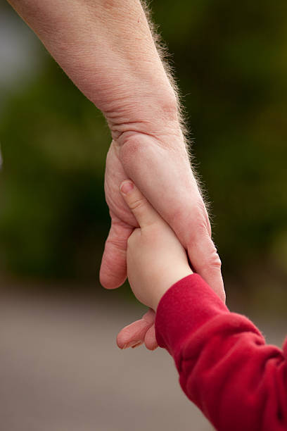 istock Mature woman holding hands with young child 149074881