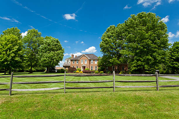 Suburban Maryland Single Family Georgian House Home Lawn Fence Trees Single family house on large plot of land in suburban Maryland.  Georgian/Colonial Style. Rail fence in foreground. - see lightbox for more rail fence stock pictures, royalty-free photos & images