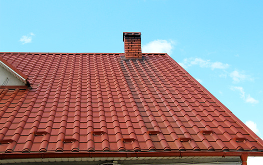 The house, the roof of which is covered with metal tiles