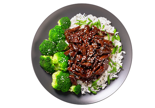 plate of  teriyaki beef, rice, broccoli and sesame seeds isolated on white background, top view