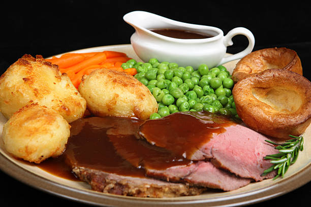 British roast beef dinner with Yorkshire puddings. Shallow DoF, sharp focus at centre of image.
