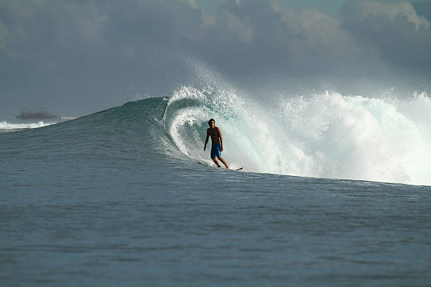 Surfer on wave, Indonesia Surfer riding tropical blue wave, Indonesia Mentawai Islands stock pictures, royalty-free photos & images