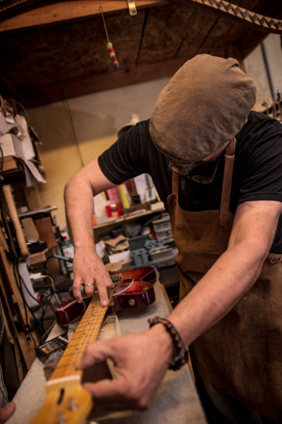 istock Applying strings to a new handmade electric guitar 1490758605