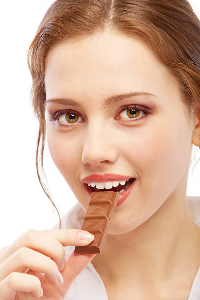 istock Beautiful young woman bites off chocolate 149075870