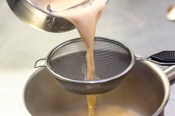 istock Cooking in the restaurant kitchen. Sifting sauce through a sieve. Chef is filtering sauce. High quality photo 1490761224