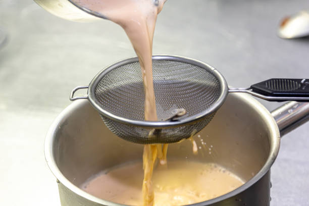 istock Cooking in the restaurant kitchen. Sifting sauce through a sieve. Chef is filtering sauce. High quality photo 1490761243