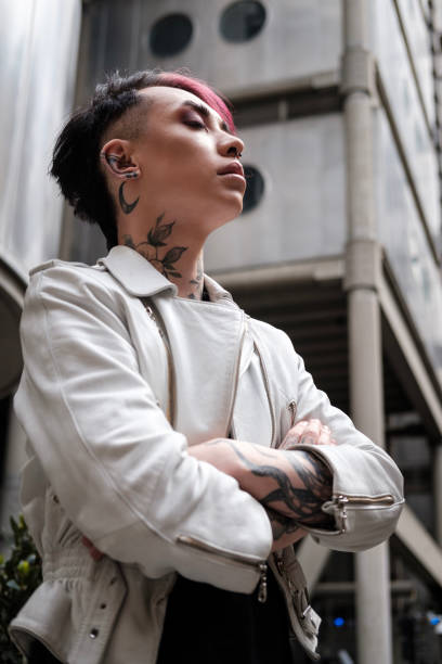Pensive and relaxed androgynous model in futuristic environment in London. Edgy outfit, alternative model.