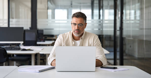 istock Mature Latin business man ceo trader using computer working in modern office 1490764597