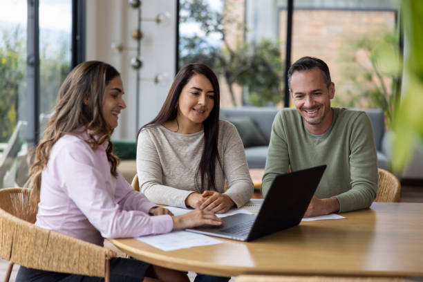 istock Happy real estate agent going through financial options with a couple 1490765021
