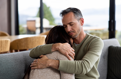 Shot of an elderly woman embracing her daughter at home